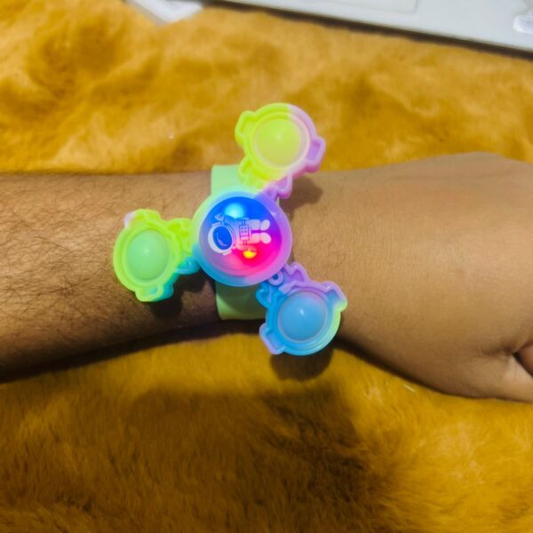 The Wrist Band with LED Popit Spinner is a wearable toy that combines a fidget spinner with a wristband. Typically made with colorful materials, the wrist band incorporates a pop-it style fidget spinner with LED lights. This accessory is designed for both entertainment and stress relief. Users can wear it on their wrists and engage with the pop-it spinner for a tactile experience, and the LED lights add a visually appealing element. The Wrist Band with LED Popit Spinner serves as a portable and multifunctional accessory for individuals looking for a combination of fidgeting and visual stimulation.