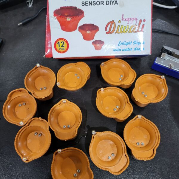The "Water LED SENSOR DIYA (12PC BOX)" is a set of 12 LED diyas designed for decorative and celebratory purposes. These LED diyas are intended to replicate the traditional oil lamps, or diyas, commonly used in Indian festivals and cultural events. What makes them unique is the water sensor feature, which means that they illuminate when they come into contact with water. This feature offers a safe and convenient way to enjoy the warm and inviting glow of diyas without the use of an open flame. These LED diyas come in a box containing 12 units and are commonly used to add a festive and spiritual ambiance to various occasions, particularly during festivals like Diwali.