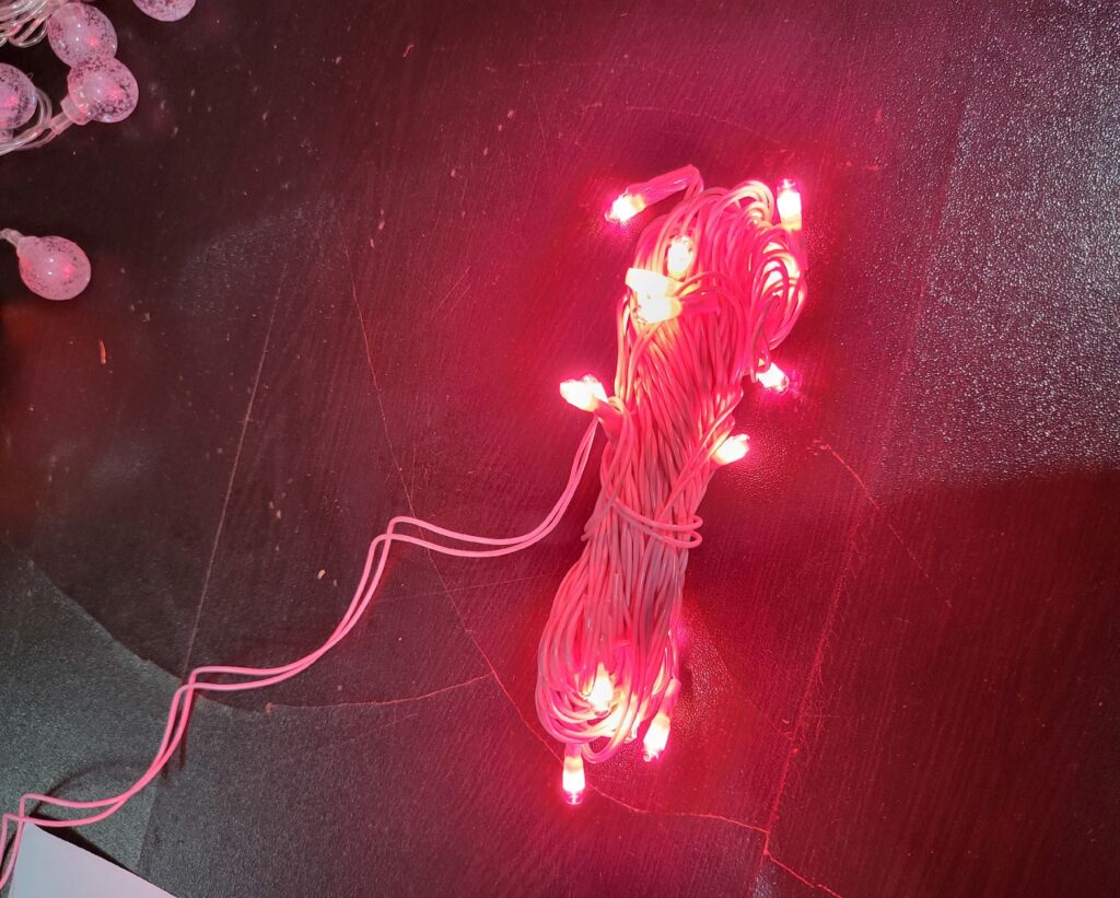 a decorative lighting product with warm pink LED lights attached to a wire. It's often used for creating a cozy and enchanting ambiance in various settings. The wire allows for flexible and creative placement of the lights, making it suitable for decorating both indoor and outdoor spaces.