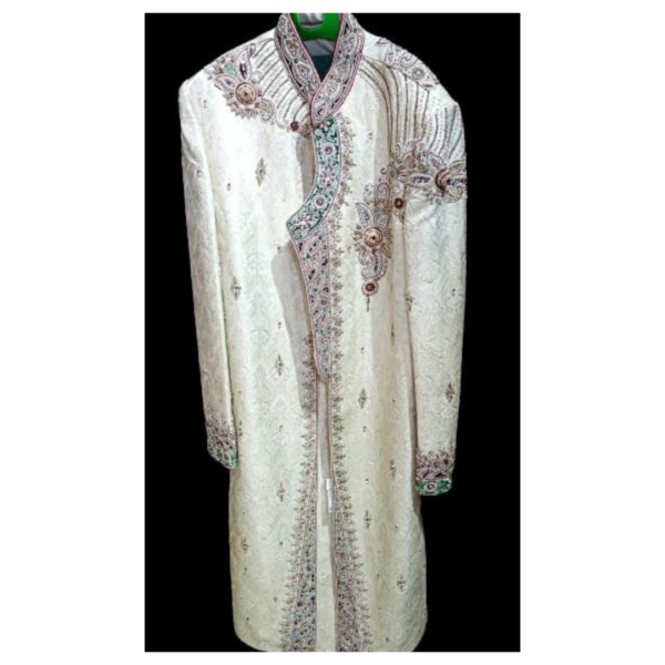 In the case of the Vista White Ornamental Sherwani, the primary color is white, symbolizing purity and elegance. The term "ornamental" indicates that the sherwani is adorned with decorative elements, which could include intricate embroidery, sequins, beads, or other embellishments. These embellishments are often meticulously crafted to create a luxurious and regal appearance, enhancing the overall aesthetic of the attire.