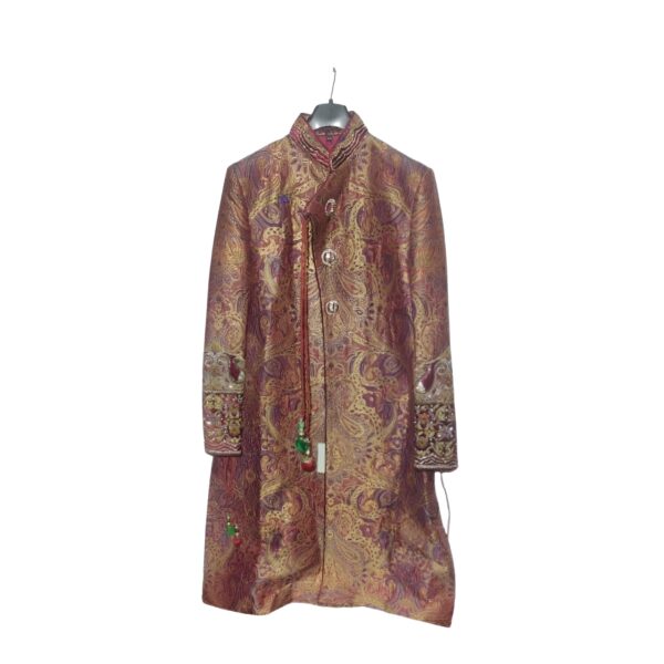 The rich maroon hue of the sherwani sets the tone for sophistication. The intricate prints and patterns add a touch of classical charm, reflecting the artistry of Indian craftsmanship. Embellished with tasteful details, this sherwani captures the essence of traditional attire while incorporating modern elements.
