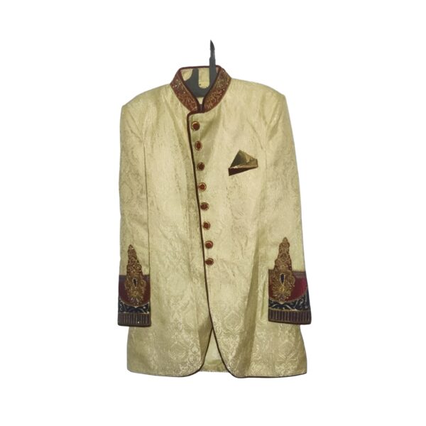 This resplendent sherwani features a rich gold color, symbolizing opulence and grandeur. The intricate craftsmanship and detailing showcase the skilled artistry that goes into creating this traditional garment. The maroon accents add a touch of royal charm, creating a striking contrast that enhances the overall appeal.